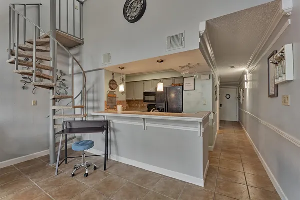 a kitchen with cabinets and chairs