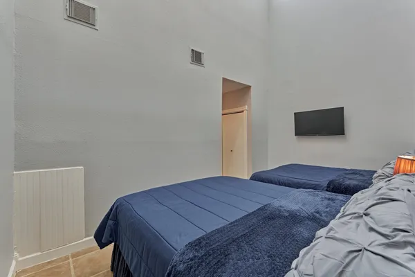 a bedroom with a bed and a flat screen tv