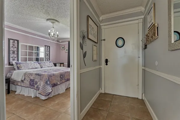 a spacious bedroom with a bed and a chandelier