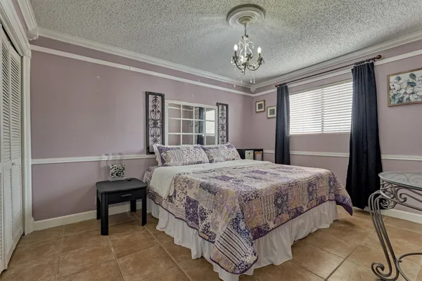 a bedroom with a bed and a chandelier