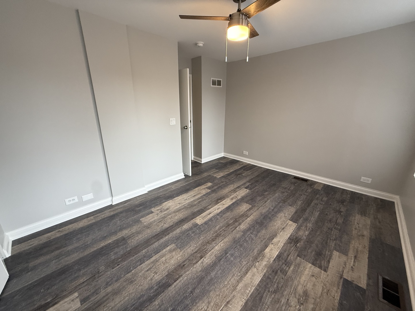 744 West Gordon Terrace, Unit 303 Chicago, IL 60613 - Photo 11 of 14 an empty room with wooden floor and fan
