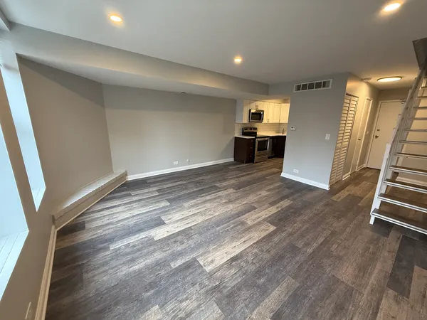 en empty room with wooden floor and stairs