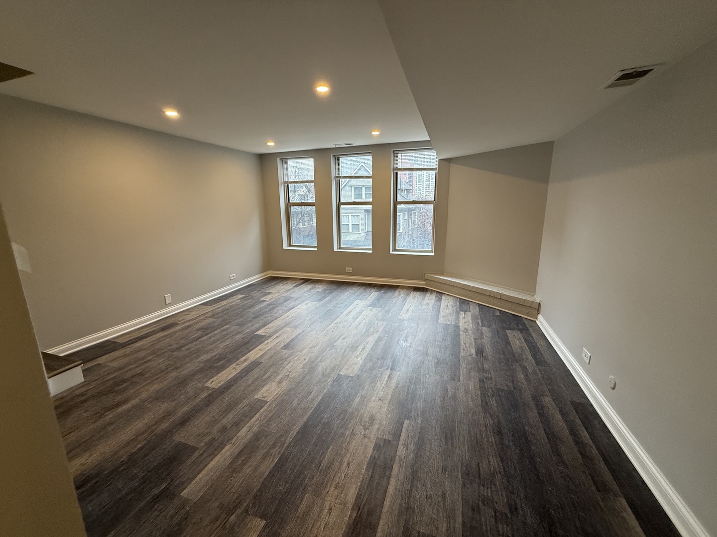 744 West Gordon Terrace, Unit 303 Chicago, IL 60613 - Photo 4 of 14 a view of an empty room with wooden floor and a window
