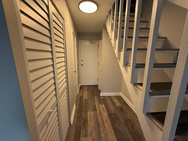 a view of a hallway with wooden floor and staircase