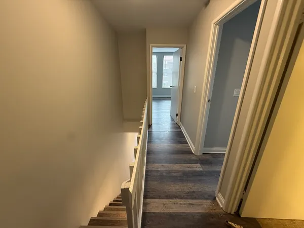 a view of a hallway with wooden floor and entryway