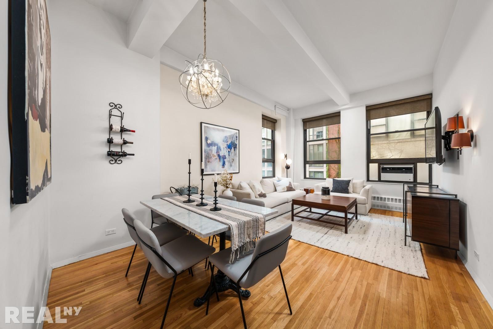 a view of a dining room with furniture a chandelier and wooden floor