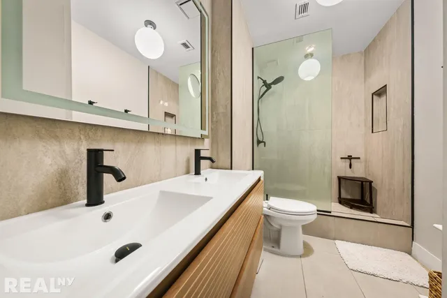 a kitchen with stainless steel appliances granite countertop a stove top oven a sink dishwasher and a refrigerator with wooden cabinets