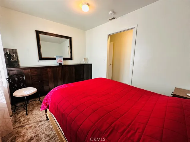 a bedroom with a bed lamp and a large window