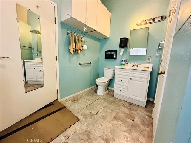 a view of an empty room with furniture and a refrigerator