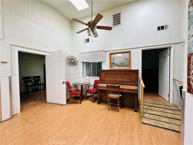 a kitchen with a table chairs refrigerator and wooden floor