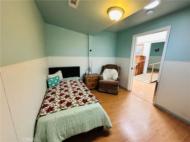 a bedroom with bed and paintings on the wall