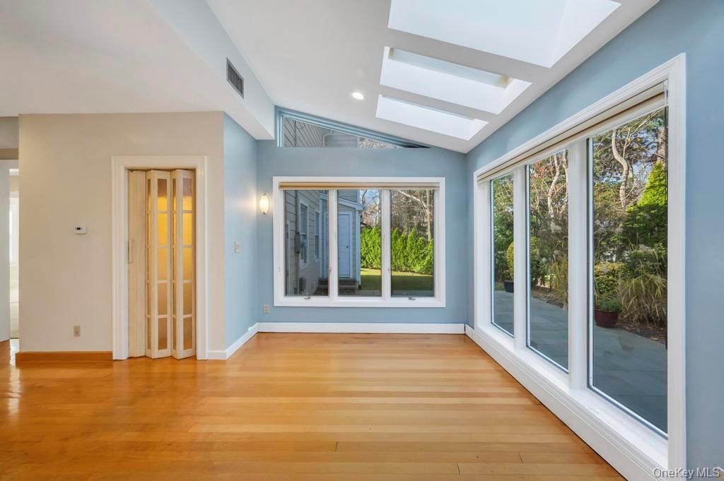 9 Sycamore Drive Great Neck, NY 11021 - Photo 19 of 49 a view of an empty room with wooden floor and a window
