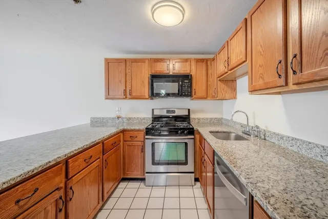 a kitchen with granite countertop a stove sink and cabinets