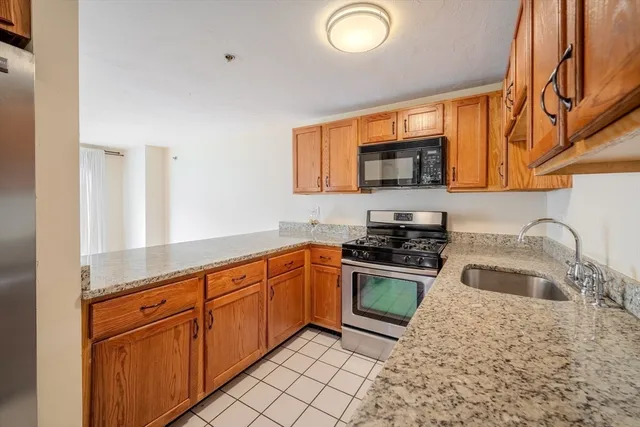 a kitchen with stainless steel appliances granite countertop a sink stove and cabinets