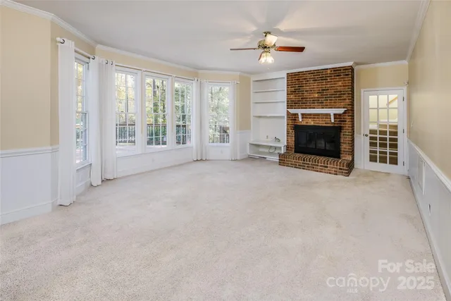 a view of an empty room with a fireplace and a window