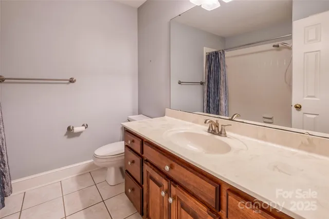 a bathroom with a sink a toilet a mirror and shower