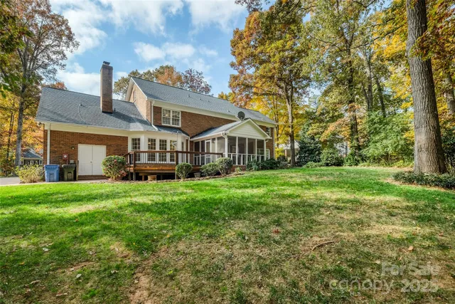 a view of a house with a big yard and large trees