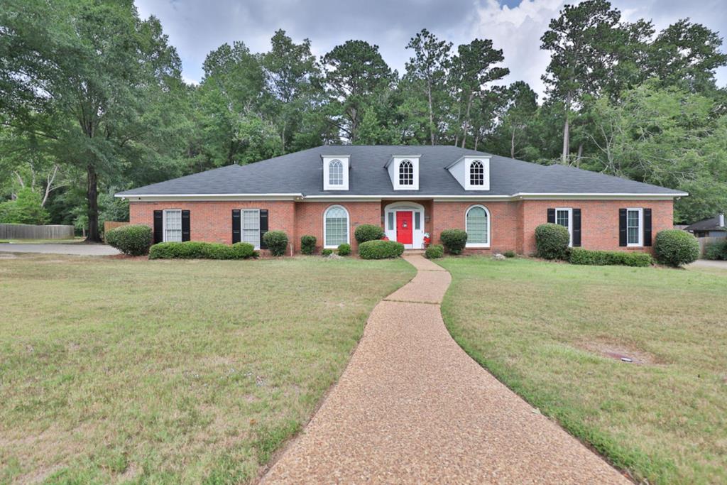 a front view of a house with a yard and trees