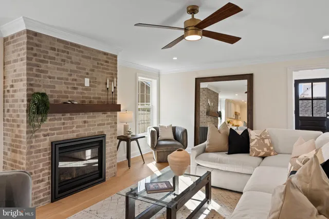 a living room with furniture a mirror and stairs