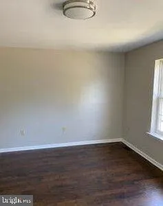a view of a small space with wooden floor and a window