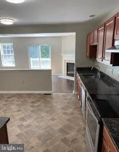 a kitchen with granite countertop a sink stove and cabinets