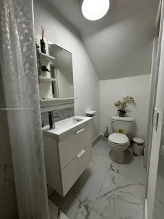 a bathroom with a toilet a sink and mirror