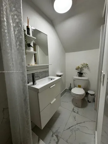 a bathroom with a toilet a sink and mirror