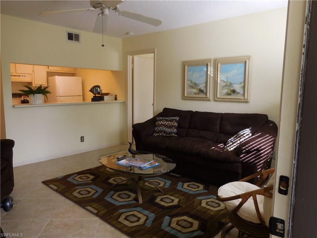 4287 27th Court Southwest, Unit 202 Naples, FL 34116 - Photo 1 of 22 a living room with furniture and a table