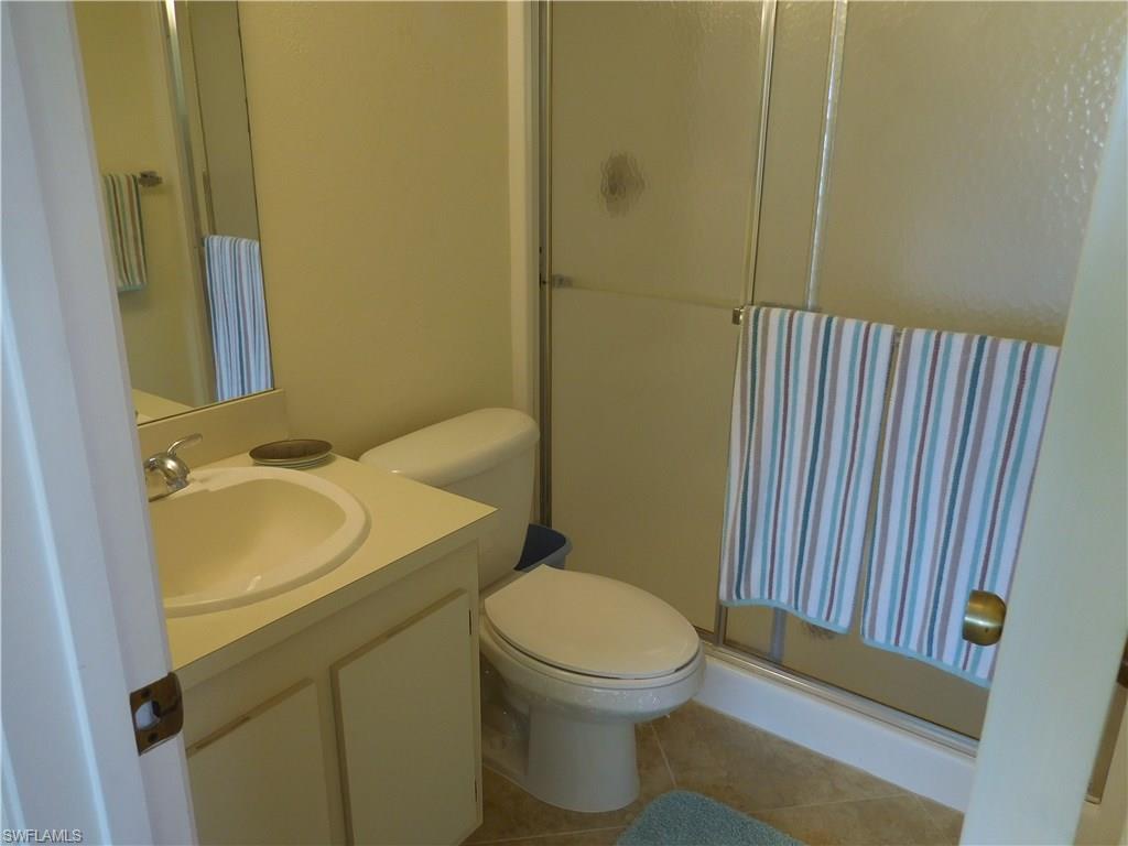 4287 27th Court Southwest, Unit 202 Naples, FL 34116 - Photo 11 of 22 a white toilet sitting next to a bathroom sink