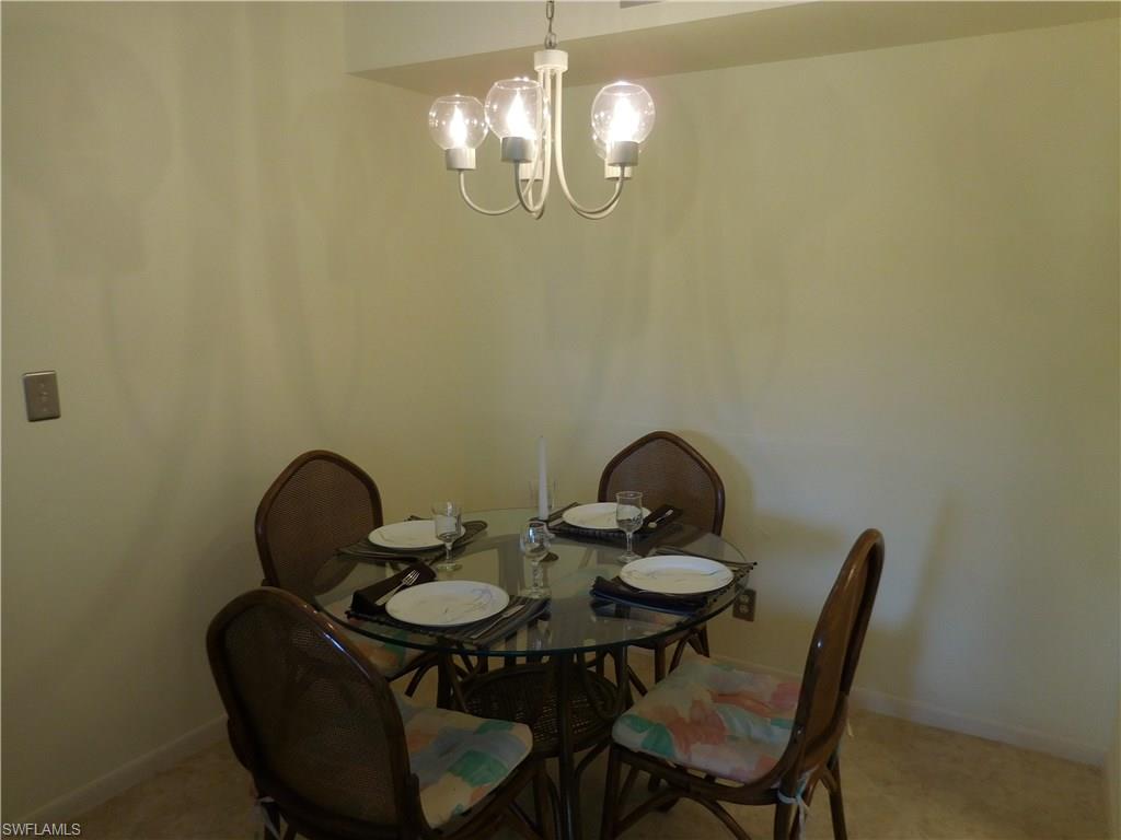 4287 27th Court Southwest, Unit 202 Naples, FL 34116 - Photo 12 of 22 a view of a dining room with furniture and chandelier