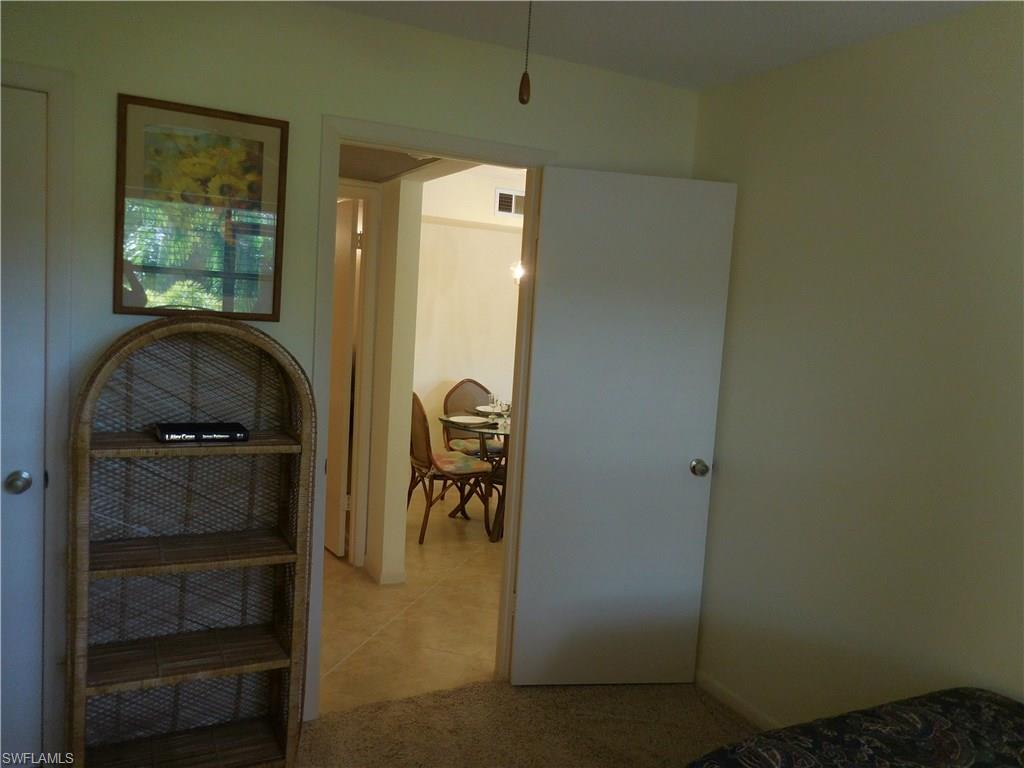 4287 27th Court Southwest, Unit 202 Naples, FL 34116 - Photo 15 of 22 a bedroom with a bed and a closet