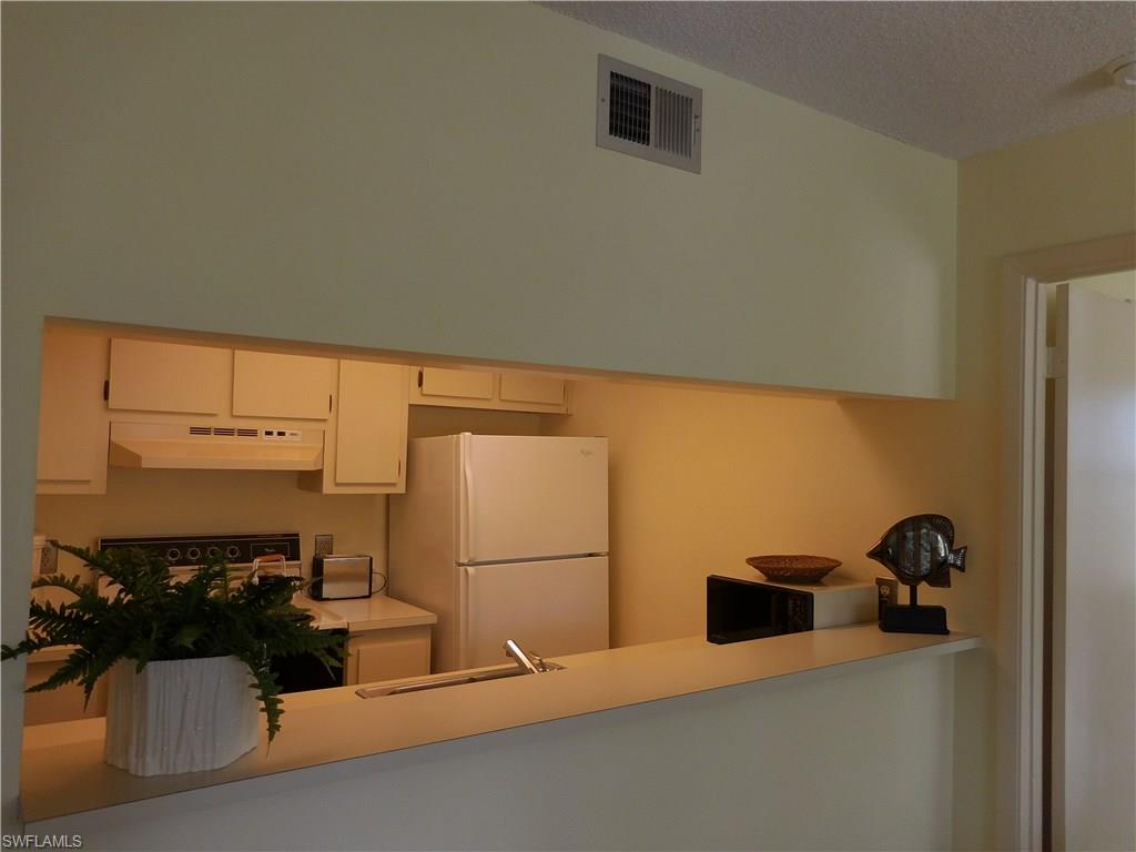 4287 27th Court Southwest, Unit 202 Naples, FL 34116 - Photo 6 of 22 a kitchen with a refrigerator and a stove