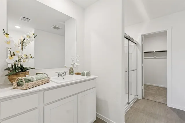 a spacious bathroom with a granite countertop sink and a mirror