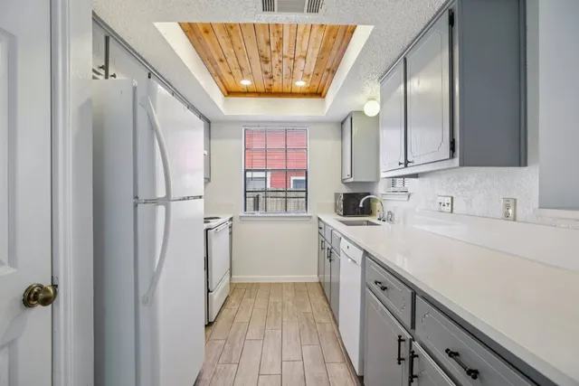 a kitchen with a sink a refrigerator and cabinets