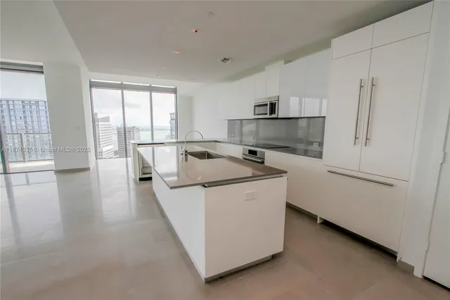 a view of kitchen with stainless steel appliances a white stove top oven and white cabinets