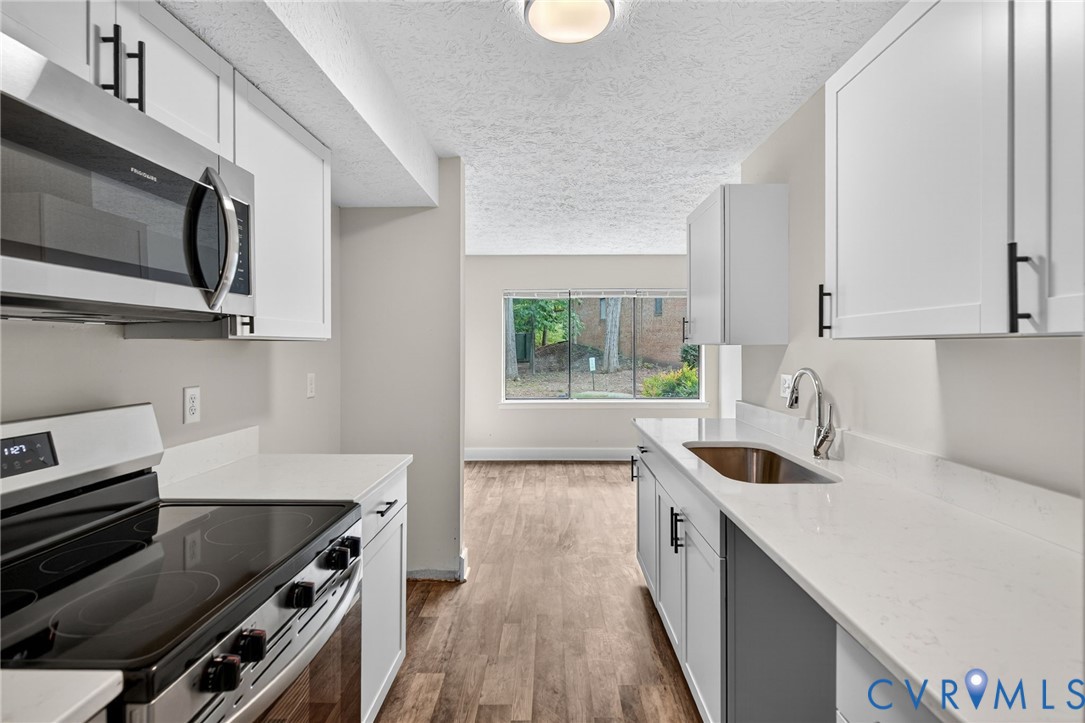 1501 Bronwyn Road, Unit 101 Henrico, VA 23238 - Photo 12 of 24 a kitchen with stainless steel appliances a stove a sink and a microwave