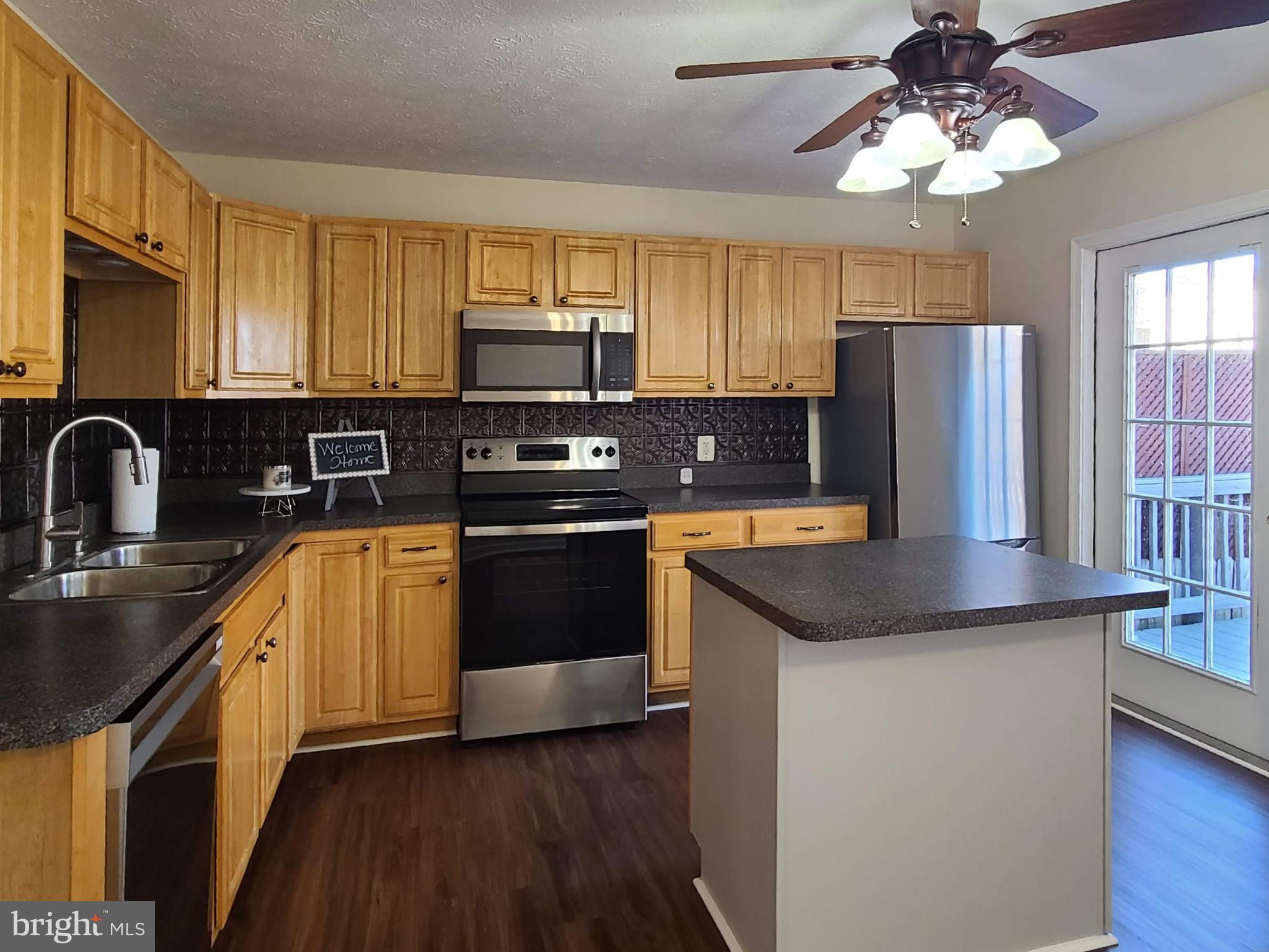 106 Regina Lane Fredericksburg, VA 22405 - Photo 14 of 31 a kitchen with stainless steel appliances granite countertop a sink a stove a refrigerator cabinets and wooden floor