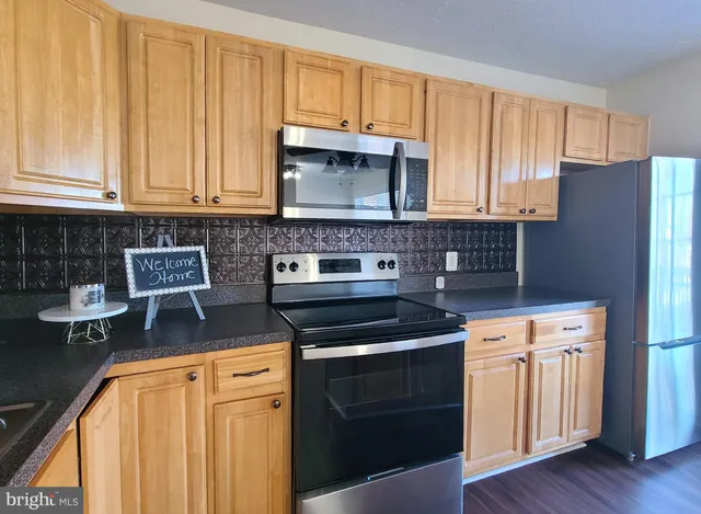 a kitchen with stainless steel appliances granite countertop a sink stove and microwave
