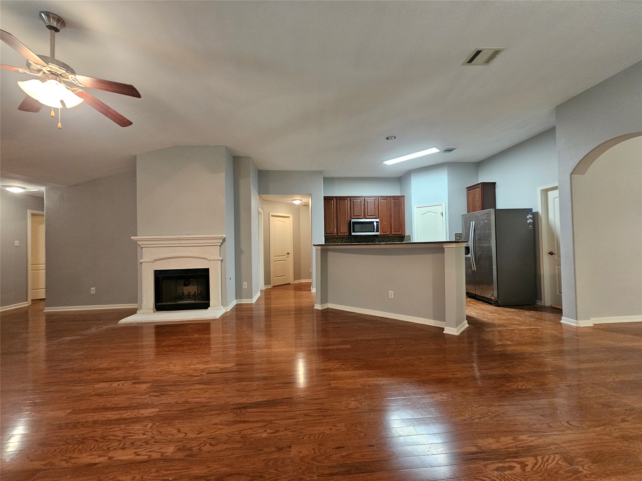 2035 Intrepid Drive Buda, TX 78610 - Photo 6 of 26 A welcoming living space features warm hardwood flooring and a prominent fireplace.