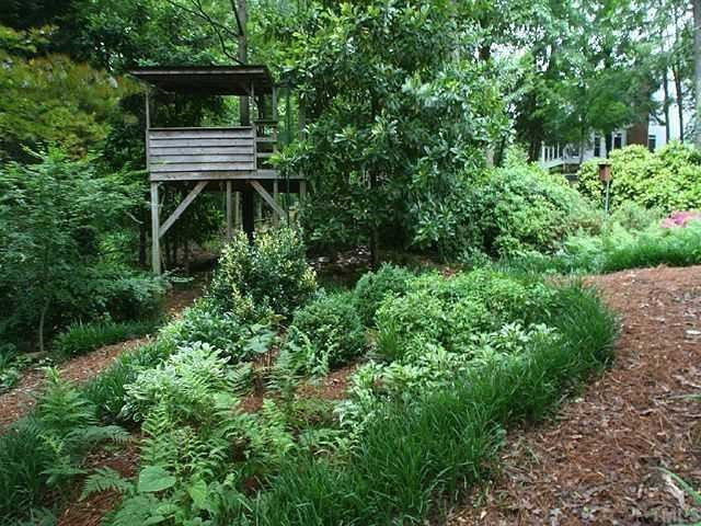 2605 Wells Avenue Raleigh, NC 27608 - Photo 11 of 12 Wonderful playhouse is hidden among the plentiful shrubs, plantings & trees in the back yard. Yard