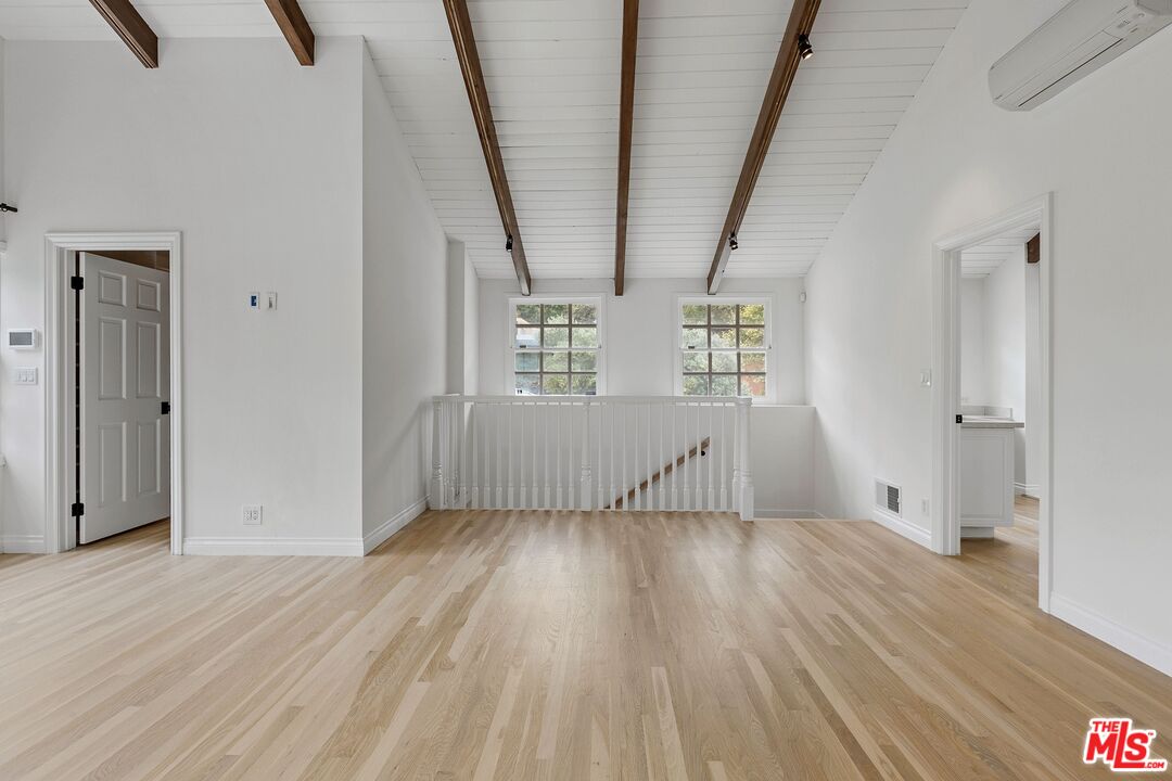 1462 Rising Glen Road Los Angeles, CA 90069 - Photo 24 of 39 a view of an empty room with wooden floor and a window