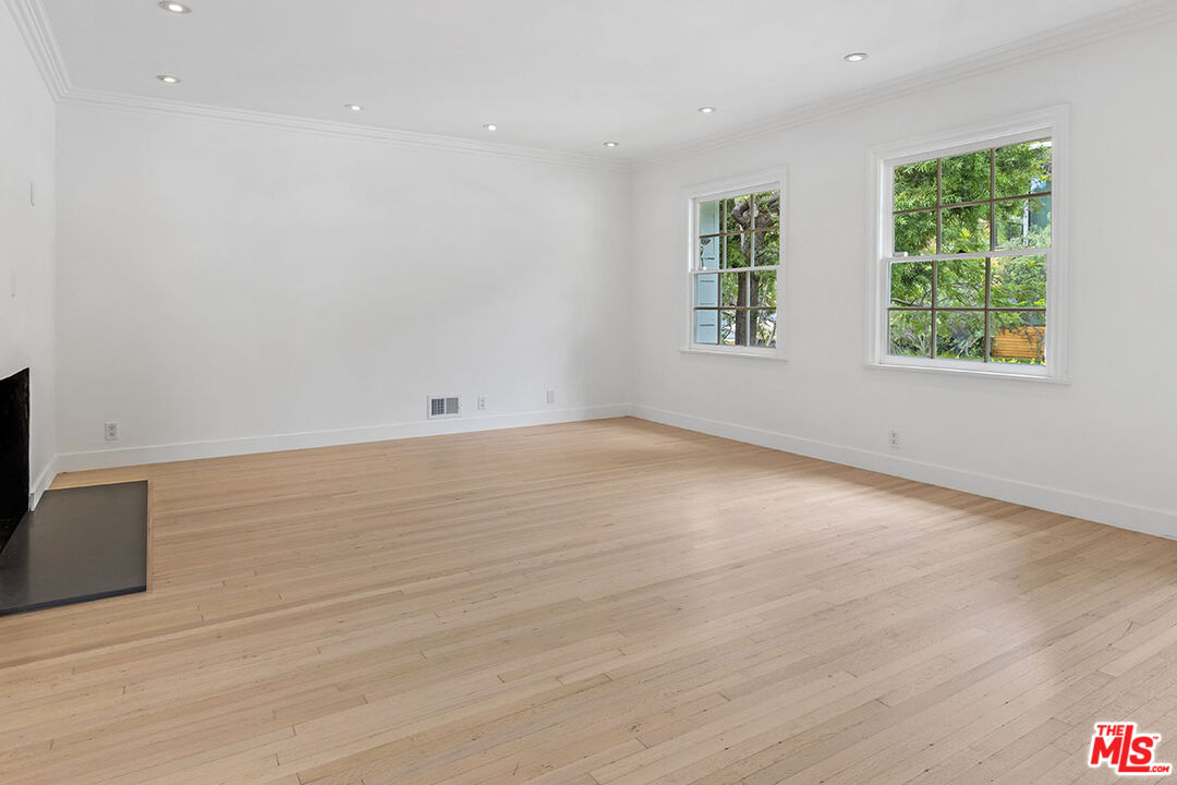 1462 Rising Glen Road Los Angeles, CA 90069 - Photo 5 of 39 an empty room with wooden floor and windows