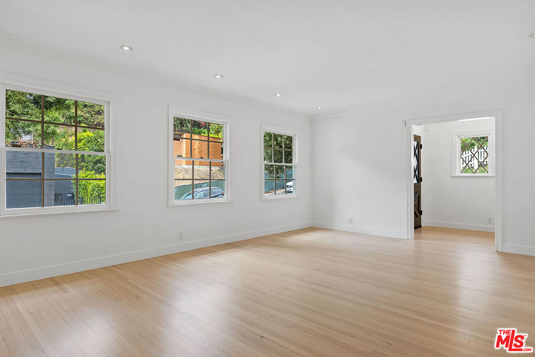 1462 Rising Glen Road Los Angeles, CA 90069 - Photo 7 of 39 a view of an empty room with wooden floor and a window