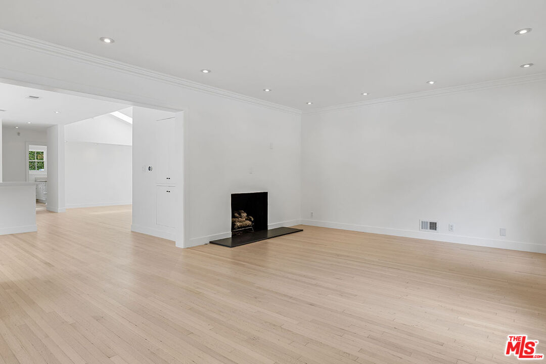 1462 Rising Glen Road Los Angeles, CA 90069 - Photo 10 of 39 an empty room with fireplace and wooden floor
