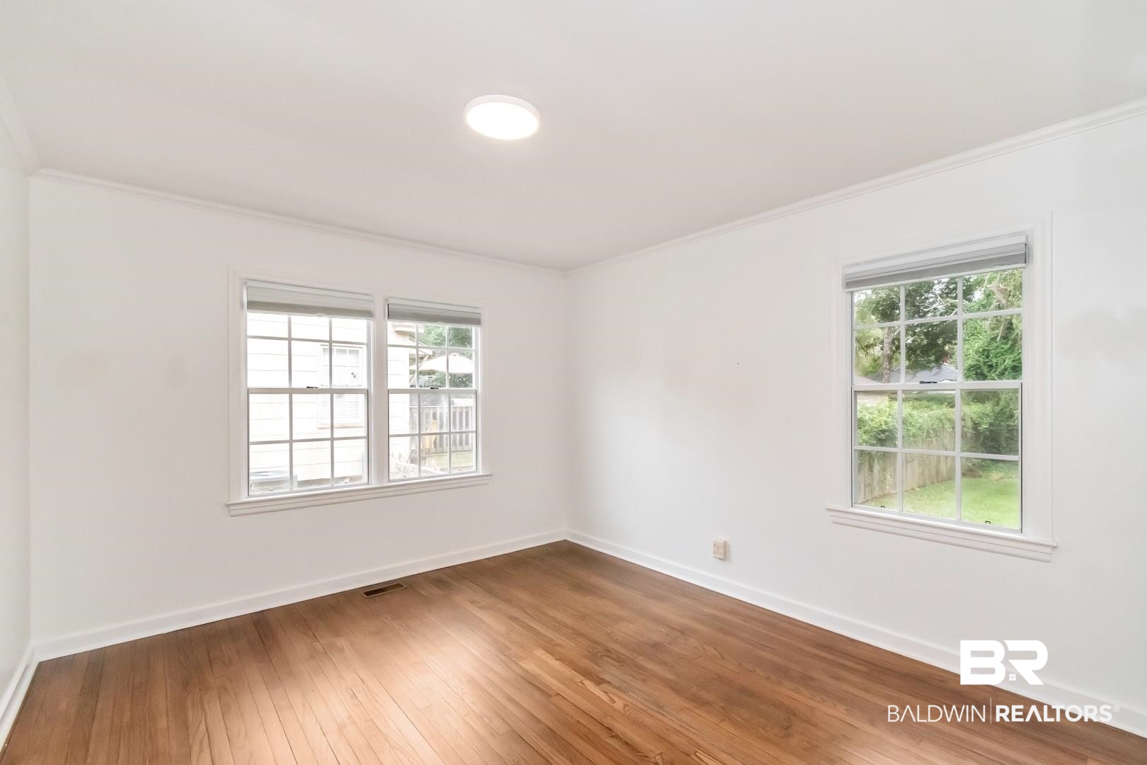208 Morgan Avenue Mobile, AL 36606 - Photo 16 of 27 Spare room with wood-type flooring, plenty of natural light, and ornamental molding