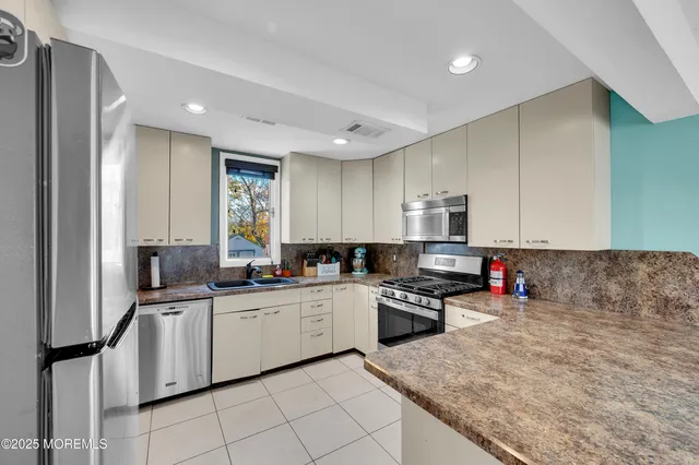 a kitchen with stainless steel appliances granite countertop a sink stove and refrigerator