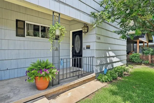 a house with a flower garden and potted plants