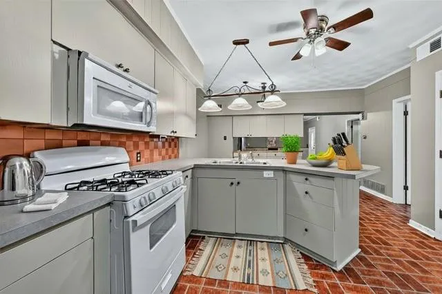 a kitchen with stainless steel appliances granite countertop a stove a sink and white cabinets