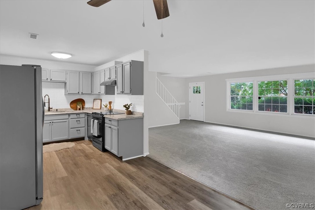 9419 Camrose Road Henrico, VA 23229 - Photo 9 of 29 a kitchen with a refrigerator a stove top oven a sink and dishwasher with wooden floor