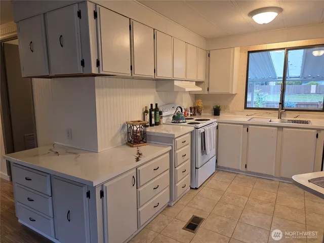 a kitchen with white cabinets and white appliances